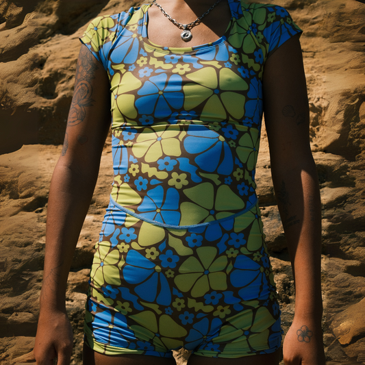 A woman wearing a shortie swimsuit with a geometric floral pattern in blue and green colors.
